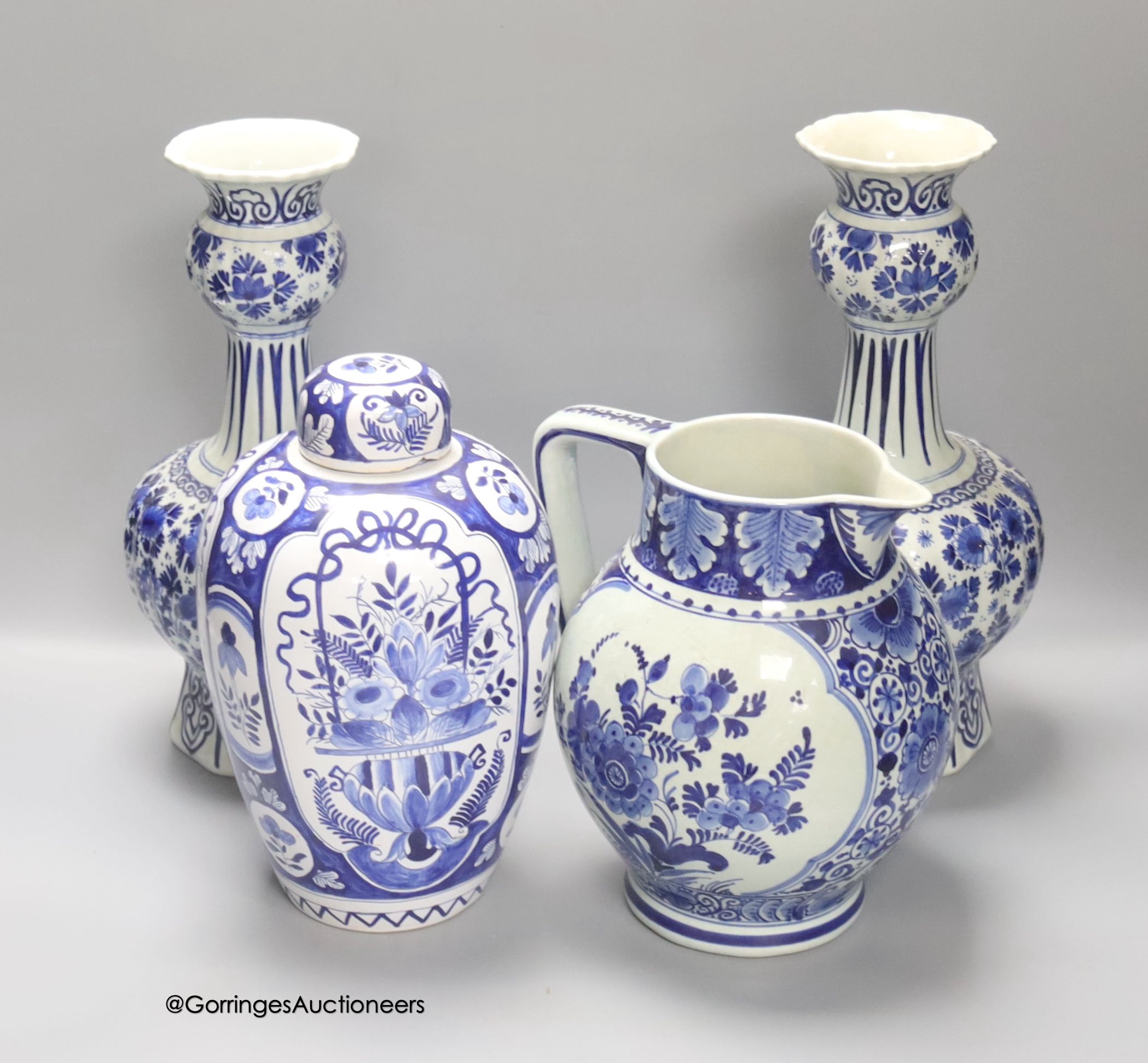 A pair of Dutch Delft blue and white vases, 29cm, a similar ovoid jar and cover and a bulbous jug